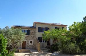 a stone house with trees in front of it at Villa spacieuse avec piscine à Saint-Michel-d'Euzet in Saint-Michel-d'Euzet