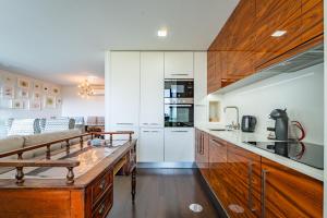 a kitchen with white cabinets and a wooden table at Sun, Sea, and Comfort Apartment in São Félix da Marinha