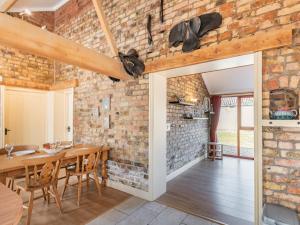 a kitchen and dining room with a brick wall at The Tack Rooms - Uk37520 in Routh