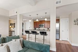 an open kitchen and living room with a green couch at Experience comfort at Quill Haven - Pet Friendly in Grand Haven