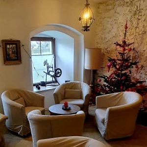 a living room with a christmas tree and chairs at Dworek Marmis - idealny dla rodzin in Mirsk