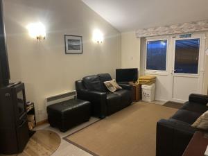 ein Wohnzimmer mit zwei Stühlen und einem Fernseher in der Unterkunft Hopeman Cottages in Hopeman