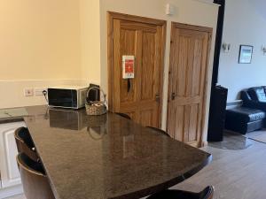 eine Küche mit einer Theke mit einem Tisch mit einer Mikrowelle in der Unterkunft Hopeman Cottages in Hopeman + 6 Fotos