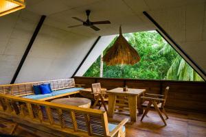 uma sala com uma mesa e cadeiras e uma janela em Satya Boutique Resort & Spa em Havelock Island