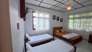 a bedroom with two beds and a window at Ceylon Bliss Retreat- Kandy Wellness Hotel in Kandy