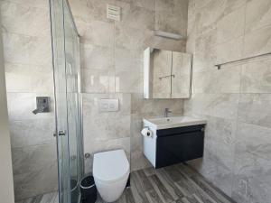 ein Badezimmer mit Toilette, Waschbecken und Dusche in der Unterkunft Caesar Resort & Spa Luxury Apartments in Iskele + 22 Fotos