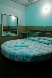 a large bed in a room with a large mirror at New Auto Motel in Barcelona