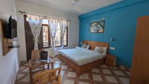 Un dormitorio con una cama y una pared azul. en The Bran Saga, en Haripūr