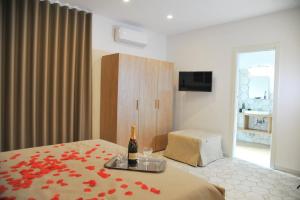 a bedroom with a bottle of wine on a bed at Domus Fontana in Pompei