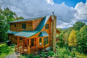 a cabin in the woods with a green roof at Peaceful View in Linville Falls