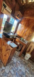 Una computadora portátil sobre un escritorio de madera en una habitación. en Memo's Cabañas, en Tamanique