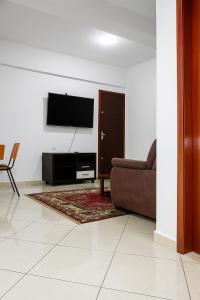 a living room with a couch and a television on a wall at Apartamento completo e bem localizado 302 in Vitória da Conquista