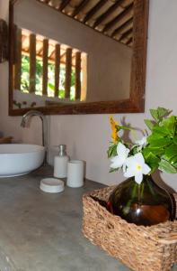 a bathroom with a sink and a vase with flowers in it at Casa Paracatoá - Icapuí in Icapuí +37 photos