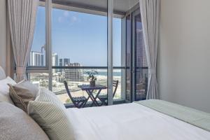 a bedroom with a bed and a view of the beach at Urban Chic - Shams Meera in Abu Dhabi