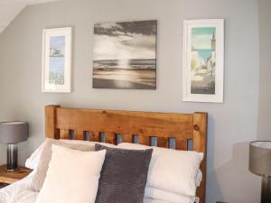 a bedroom with a bed with three pictures on the wall at Cwrt in Dwyran