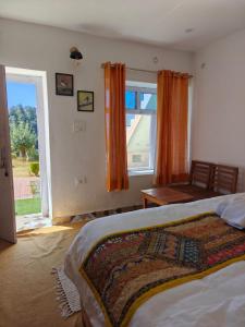 a bedroom with a bed and a large window at Buransh Retreat in Jageshwar
