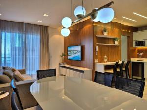 a kitchen and dining room with a white table and chairs at CURTA!|216|Brava Arts|2 Suítes| Sofisticada Vista in Cabeçudas