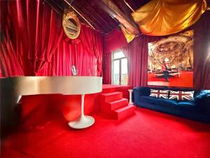 a red living room with a couch and a lamp at 10 Très Grande Chambre insolite double volume XL, proximité gare de tourcoing in Tourcoing