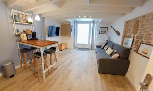 a living room with a couch and a table at Séjour couple ou solo Maisonnette tout confort - calme et proximité commerces, plage, restaurants et axes routiers in Ouistreham