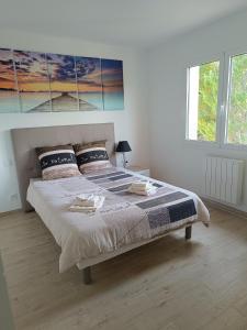 a white bedroom with a large bed with two pillows at Belvédère du bonheur in Samatan
