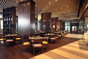 ein Restaurant mit Tischen und Stühlen in einem Raum in der Unterkunft Cinnamon Life Residencies- Luxury 2 Bedroom Apartment 12th Floor in Colombo