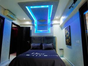 - une chambre dotée d'un lit avec une lumière bleue au-dessus dans l'établissement home away from home 2 bedroom luxury apartment gulize, à Marrakech