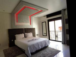 une chambre avec un grand lit et une grande fenêtre dans l'établissement home away from home 2 bedroom luxury apartment gulize, à Marrakech
