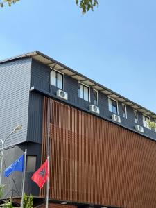 a building with two flags in front of it at Hotel Kristali in Peshkopi