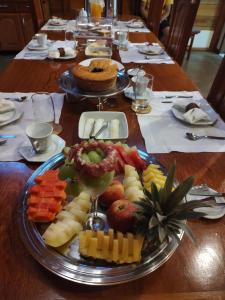 a wooden table with a plate of food on it at Pousada Vila Madeira in Sítio Selva de Pedra +27 photos