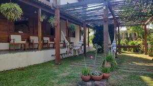 a patio of a house with chairs and plants at Pousada Vila Madeira in Sítio Selva de Pedra