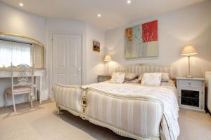 a bedroom with a large bed and a mirror at The Foundry in Burnham Market
