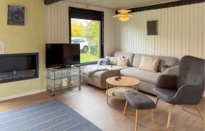 a living room with a couch and a tv at 3 Bedroom Stunning Home In Grenaa in Grenå