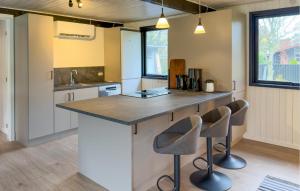 a kitchen with a large island with two stools at 3 Bedroom Stunning Home In Grenaa in Grenå