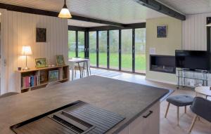an open kitchen and living room with large windows at 3 Bedroom Stunning Home In Grenaa in Grenå