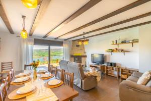 a living room with a table and chairs and a television at Gran casa rural con barbacoa ideal para familias in Villanueva