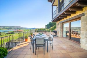 a patio with a table and chairs on a balcony at Gran casa rural con barbacoa ideal para familias in Villanueva