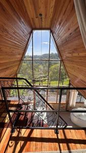 ein Zimmer mit einem großen Fenster in einem Haus in der Unterkunft Chale Pedra do Sol in Caxias do Sul