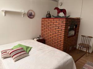 a bedroom with a bed and a brick fireplace at 60m2 studio w sauna in a semi-detached house in Lapinkangas in Oulu +5 photos