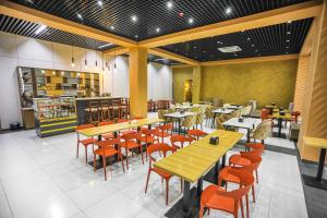 ein Restaurant mit Holztischen und Stühlen in einem Raum in der Unterkunft Diyor Hotel & Spa Tashkent in Taschkent