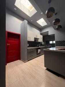 a large kitchen with a red door in a room at Infinity Apartments in Lusaka