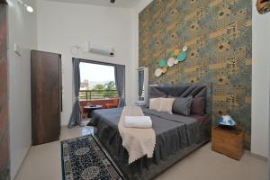 a bedroom with a large bed and a wall at ll EMPYREAN STAY ll VALENTINA VILLA ll 2BHK ll AC ll PRIVATE POOL ll in Lonavala