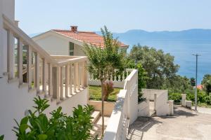 a house with a white fence and a tree at Studio Podaca 6736b in Podaca +19 photos