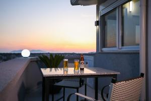 a table on a balcony with two bottles of beer at Queen Apartmets Vlore in Vlorë