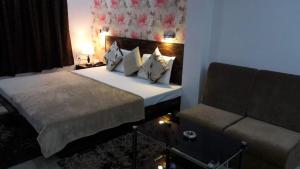 a bedroom with a bed and a couch at Hotel Kanha Inn in Lucknow