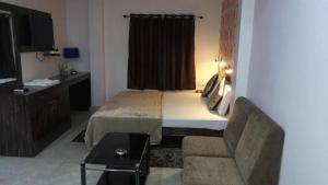 a hotel room with a bed and a chair at Hotel Kanha Inn in Lucknow +6 photos