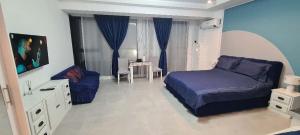 een slaapkamer met een bed, een bank en een tafel bij Studio axxis nova seaside-Parcare GRATIS in Năvodari