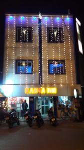 a lit up building with motorcycles parked in front of it at Hotel Kanha Inn in Lucknow