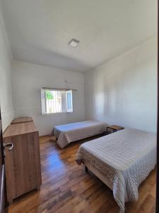 a bedroom with two beds and a window at Las Gonzalez in Olavarría