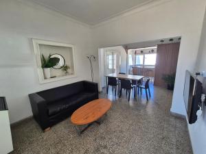 a living room with a black couch and a table at Las Gonzalez in Olavarría