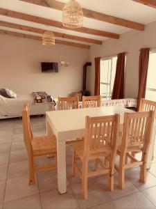 a dining room with a table and chairs and a bed at La curva in Ramallo